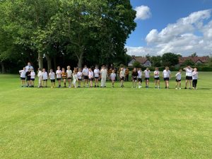 Group of people playing golf on lush green course at Inchmarlo, outdoor recreational activity.