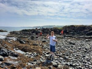 Scenic coastal landscape at Inchmarlo with rocky shoreline and visitors exploring the area.