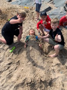 Children playing and building a sandcastle at Inchmarlo Beach, enjoying outdoor fun in a scenic coastal setting.