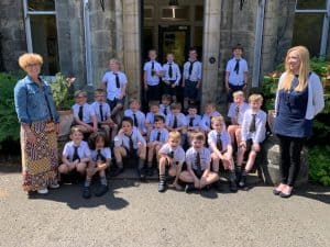 Group of students with teachers outside Inchmarlo school campus.