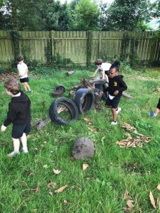 Children playing on outdoor tires and balls in a grassy area at Inchmarlo.