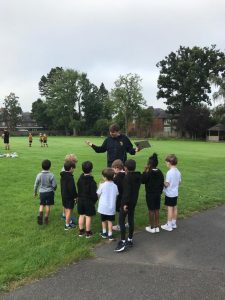 Children learning outdoor activities at Inchmarlo, a scenic park in Scotland.
