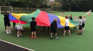 Children engaging in outdoor parachute activity at Inchmarlo play area.