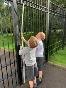 Two children playing near a black wrought iron gate at Inchmarlo estate.