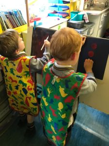 Two children engaging in creative activities at Inchmarlo nursery.