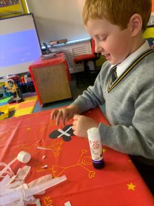 Child crafting at Inchmarlo gift shop with arts and crafts supplies, fostering creativity.