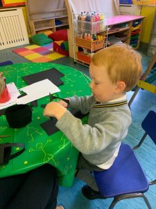 Young boy engaging in creative play at Inchmarlo childcare center.