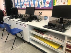 Computer classroom at Inchmarlo School with desks and tech equipment.