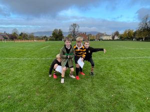 Children playing in Inchmarlo outdoor park on a sunny day, green grass and open space.