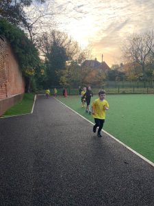Children playing on outdoor sports field in Inchmarlo, Scotland. Family-friendly park with recreational activities.