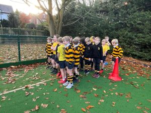 Children in school uniforms gathered outdoors on a green turf.