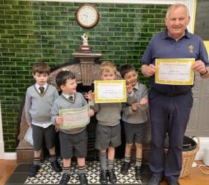 Children holding certificates at Inchmarlo School event, smiling with staff.