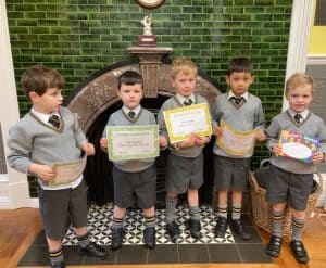 Young students holding certificates at Inchmarlo School in Scotland.