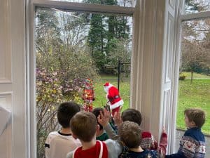 Children watching Santa from window at Inchmarlo during festive season.