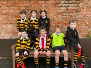 Group of children in school sports uniforms at Inchmarlo school campus.