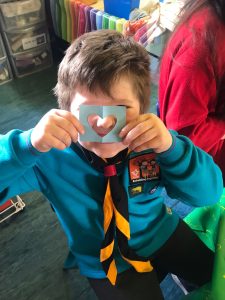 Child holding paper with heart-shaped cutout at Inchmarlo School.