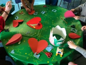 People crafting festive paper hearts at Inchmarlo event.