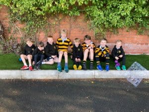 Group of children sitting outdoors at Inchmarlo, enjoying a break.