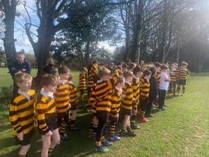 Children in striped uniforms participating in outdoor activities at Inchmarlo.