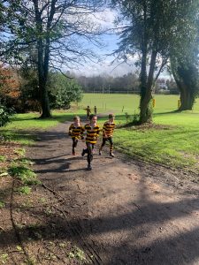 Children running in Inchmarlo garden on a sunny day, enjoying outdoor activities.