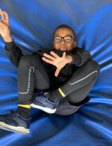 Young man relaxing on a blue fabric background at Inchmarlo estate.