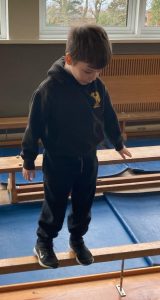 Young boy balancing on a beam at Inchmarlo, promoting childhood development and early education.