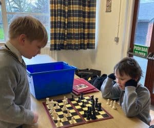Two children playing chess at Inchmarlo, a scenic estate with outdoor activities and family-friendly amenities.