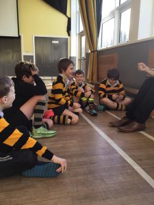 Young children sitting on the floor during educational activity at Inchmarlo Nursery.