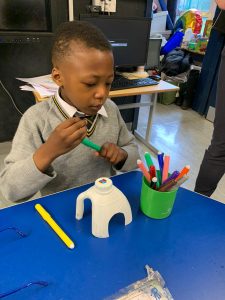 Young boy engaging in creative activity at Inchmarlo care home.