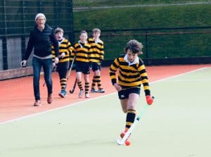 Young children playing hockey at Inchmarlo sports field.