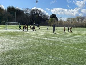 Group of children playing soccer on a lush green field at Inchmarlo.