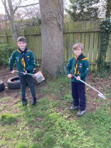 Two boys planting trees outdoors at Inchmarlo, encouraging environmental conservation and outdoor education.