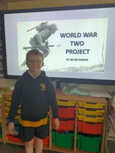 Young student presenting World War II project in classroom.