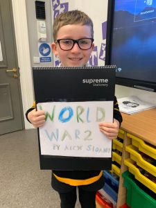 Young boy holding "World War 2" sign at Inchmarlo School.