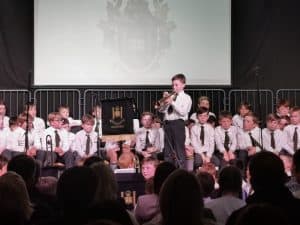 Young boy playing trumpet at Inchmarlo concert event.
