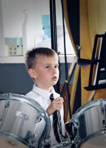 Young boy playing drums at Inchmarlo, a family-friendly destination with outdoor activities.