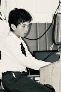 Young student working at a desk in a classroom setting.