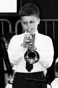 Young boy playing trumpet in school band at Inchmarlo.