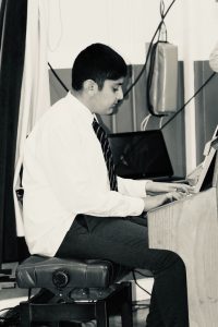 Young boy playing piano, learning music at Inchmarlo School in Scotland.