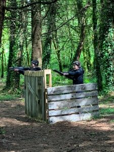 Two kids playing laser tag in lush forest scenery at Inchmarlo.