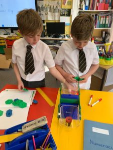 Two young students engaged in hands-on classroom activities at Inchmarlo School.