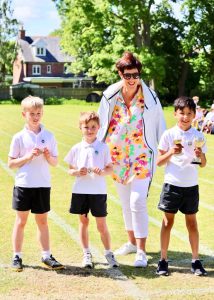 Family enjoying ice creams in scenic Inchmarlo park with lush green trees.