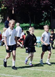 Children playing football outdoors at Inchmarlo, enjoying healthy activities in a scenic environment.