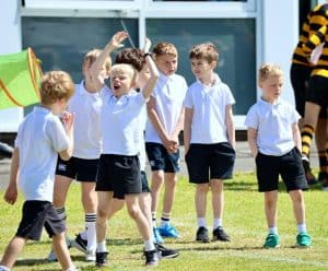 Group of children playing outside at Inchmarlo school in a sunny setting.