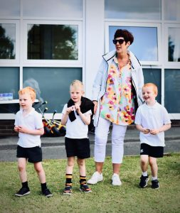 Happy woman with children outside Inchmarlo estate, showcasing luxury retirement and family living.