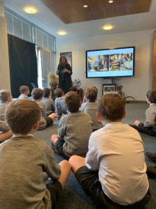 Young students listening to a teacher in classroom.