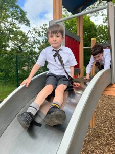 Children enjoying a slide at Inchmarlo's outdoor playground for kids' fun and recreation.