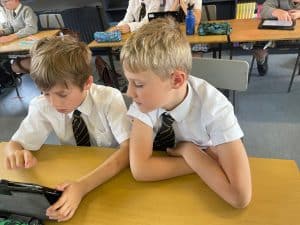 Two young boys studying with a tablet at Inchmarlo School in Scotland.