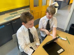 Young students working on a tablet in classroom.