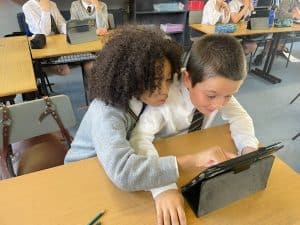 Students engaging with tablets in a classroom setting at Inchmarlo.